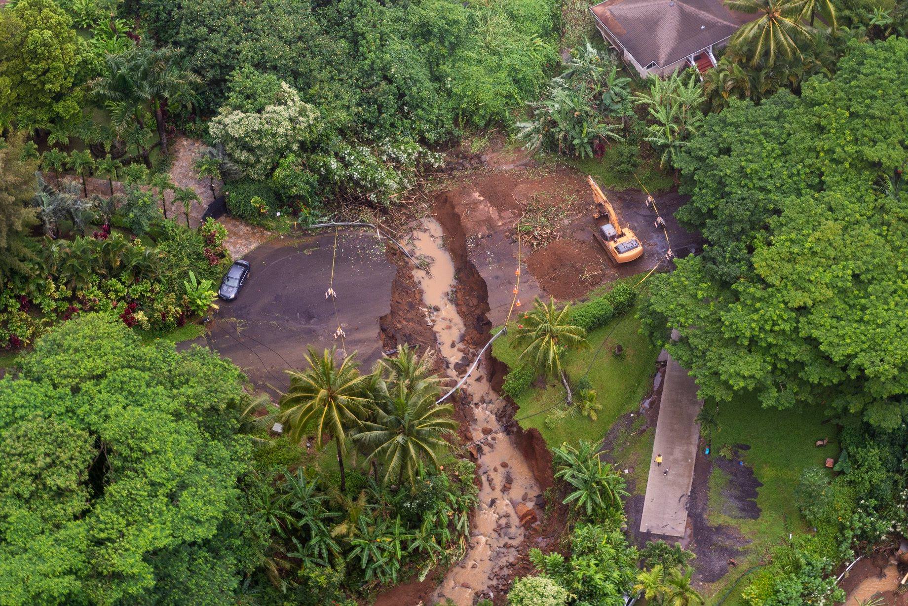 The image shows an aerial view of damage caused on Maui by Hurricane Lane in 2018, including an area where flood water caused by heavy rain running down hill destroyed a large section of pavement.