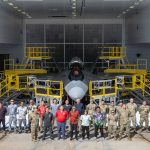 A team comprised of U.S. Air Force, Air National Guard, and contract personnel pose in front of their custom-designed F-22 Raptor maintenance stands during the debut event Sept. 26, 2024, at Joint Base Pearl Harbor-Hickam. The specialized maintenance stands are the culmination of nearly five years of collaboration between Total Force Airmen and the National Guard Bureau, providing a safer and more efficient way to access the hard-to-reach areas of one of the world’s most advanced stealth aircraft. (U.S. Air National Guard photo by Master Sgt. Mysti Bicoy)