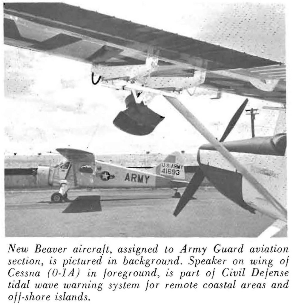 New Beaver aircraft, assigned to Army Guard aviation section, is pictured in background. Speaker on wing of Cessna (O-l1A) in foreground, is part of Civil Defense tidal wave warning system for remote coastal areas and off-shore islands.