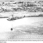 A Hawaii Army National Guard UH-1 H Huey helicopter fills a water bucket before heading back to the fire which destroyed 12,500 acres on Molokai in June.