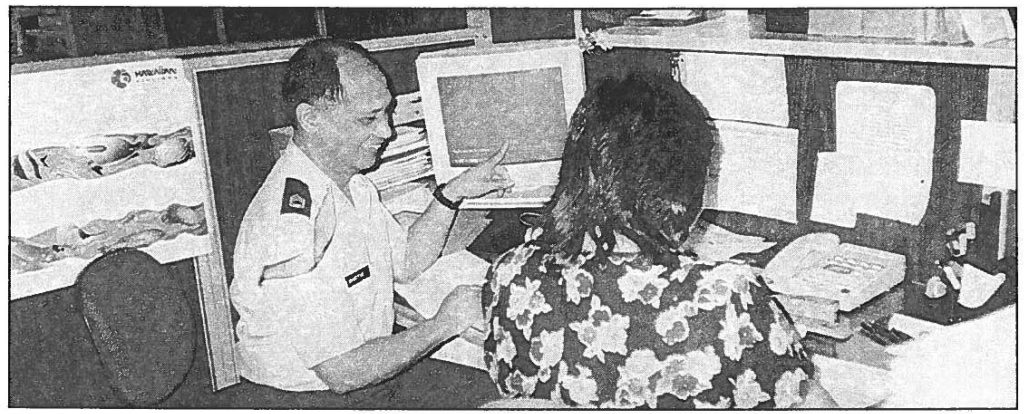 KEEPING TRACK OF THE EXPENSES--Sgt. 1st Class Raymond Ganotise discusses a travel issue with Corinthia Lucas, the supervisor of the U.S. Property and Fiscal Office's Pay and Examination Branch. Photo by Deborah M. Sanders Murray