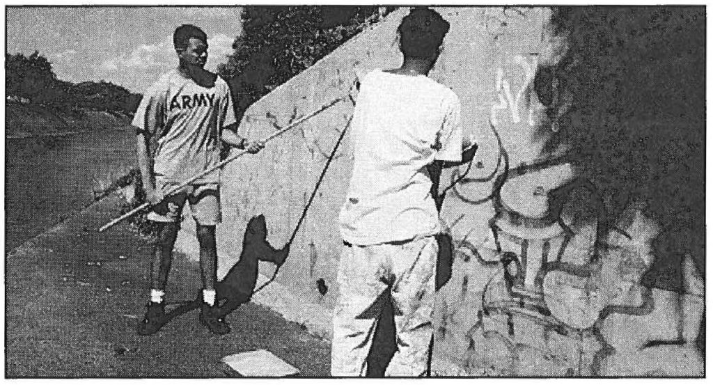 COMMUNITY CLEAN-UP- A Hawaii Army National Guard soldier and youth paint over graffiti in Pearl City. The Paint-out project was done in cooperation with the Honolulu Police Department. Sgt. Lance M. Kamisugi photo