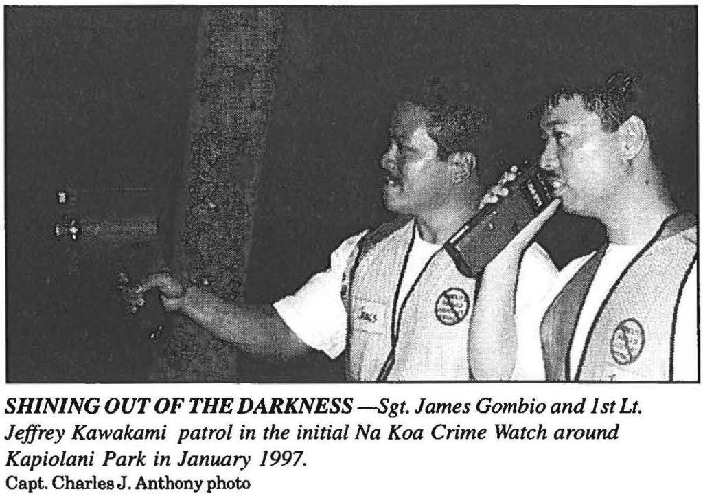 SHINING OUT OF THE DARKNESS -Sgt. James Gombio and 1st Lt. Jeffrey Kawakami patrol in the initial Na Koa Crime Watch around Kapiolani Park in January 1997. Capt. Charles J . Anthony photo