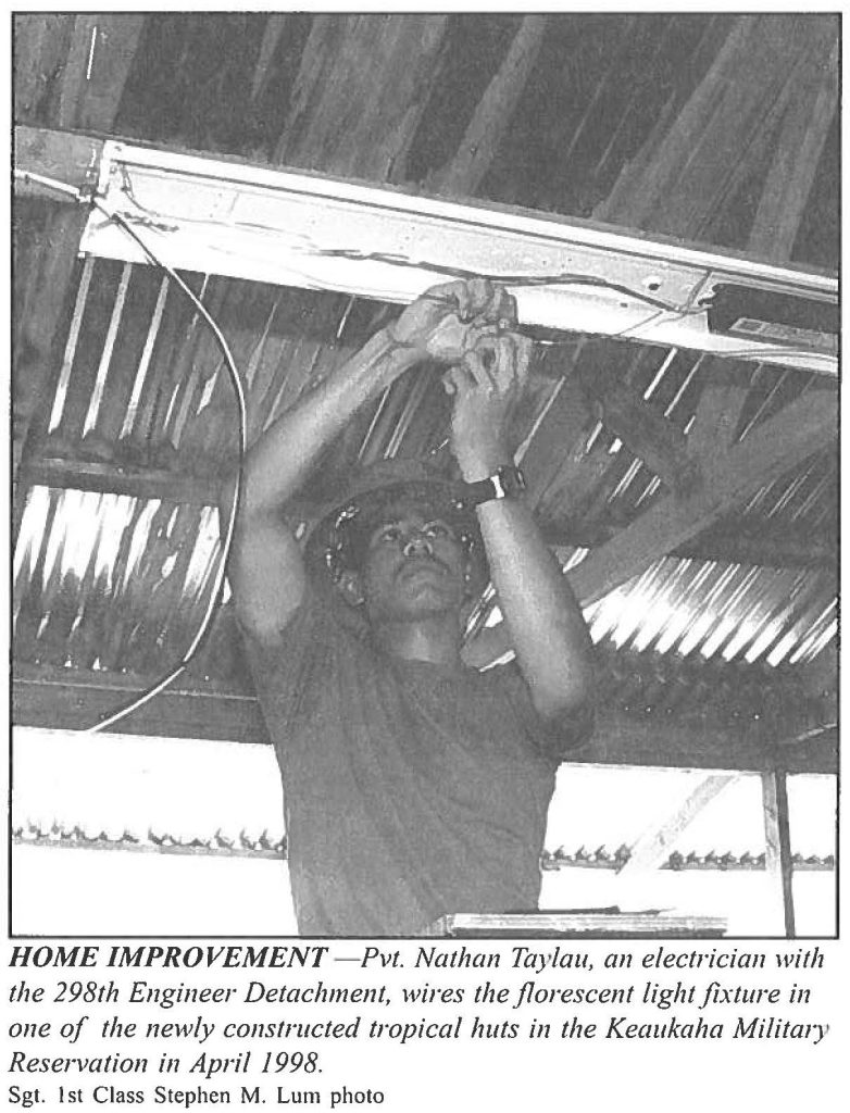 HOME IMPROVEMENT - Pvt. Nathan Taylau, an electrician with the 298th Engineer Detachment, wires the florescent light fixture in one of the newly constructed tropical huts in the Keaukaha Military Reservation in April 1998. Sgt. 1st Class Stephen M. Lum photo