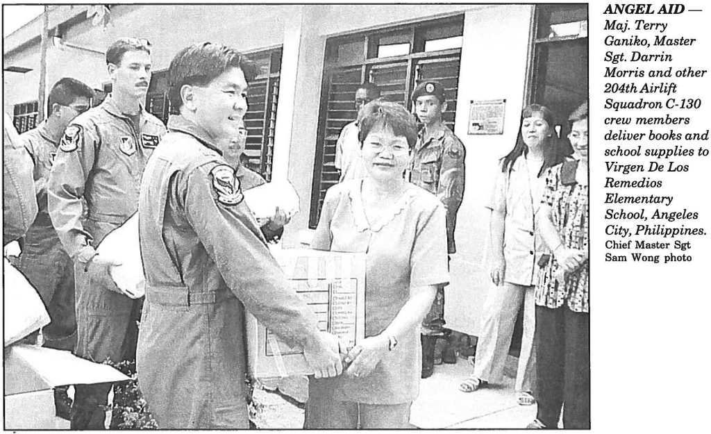 ANGEL AID Maj. Terry Ganiko, Master Sgt. Darrin Morris and other 204th Airlift Squadron C-130 crew members deliver books and school supplies to Virgen De Los Remedios Elementary School, Angeles City, Philippines. Chief Master Sgt Sam Wong photo