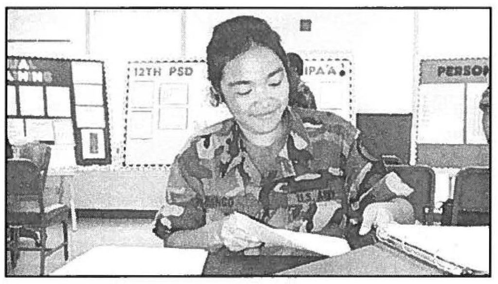 ALL IN A DAY'S WORK - Spc. Domingo prepares VIP briefing folders. Sgt 1st Class Stephen M. Lum photo