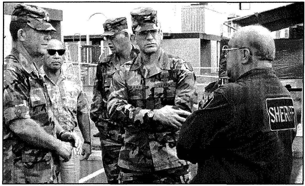 ON LOCATION UPDATE - Maj. Gen. Edward L. Correa Jr., the adjutant general; Edward T. Teixeira, vice director of State Civil .Defense; and Col. Stanley R. Keolanui Jr., Hawaii Army National Guard plans and operations military support officer, discuss the cleanup process with a sheriff's deputy Derek lnoshita photos