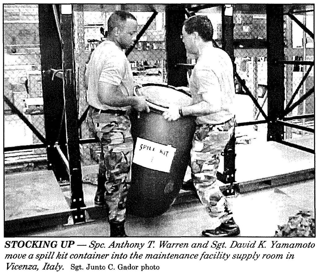 STOCKING UP - Spc. Anthony T. Warren and Sgt. David K Yamamoto move a spill kit container into the maintenance facility supply room in Vicenza, Italy. Sgt. Junto C. Gador photo