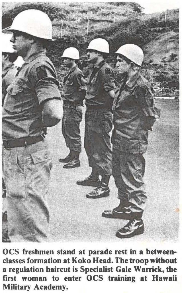 OCS freshmen stand at parade rest in a between classes formation at Koko Head. The troop without a regulation haircut is Specialist Gale Warrick, the first woman to enter OCS training at Hawaii Military Academy.