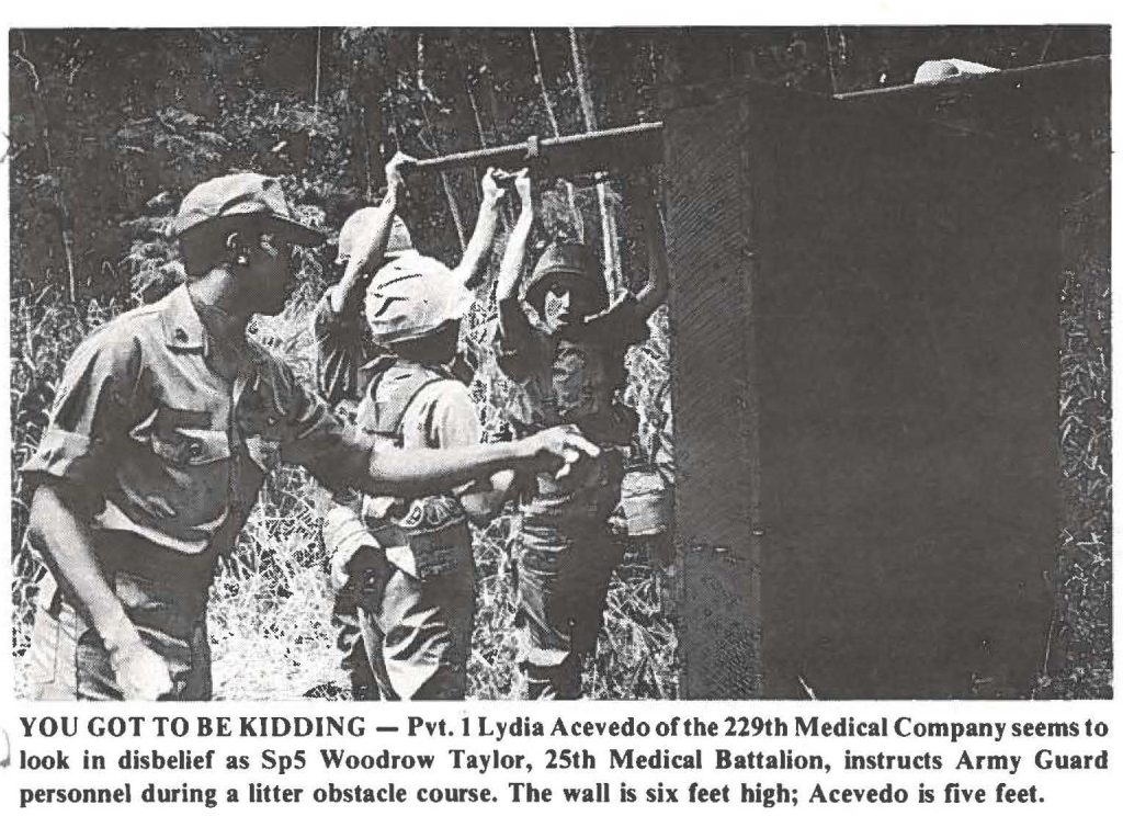 YOU GOT TO BE KIDDING - Pvt. 1 Lydia Acevedo of the 229th Medical Company seems to look in disbelief as SpS Woodrow Taylor, 25th Medical Battalion, instructs Army Guard personnel during a litter obstacle course. The wall is six feet high; Acevedo is five feet.