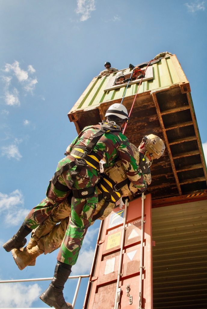 Soldier assists simulated wounded Guardsman, Kalaeloa, HI. An Indonesian Soldier assisted a simulated wounded Hawai‘i Army National Guardsman as he repeled from a building during the Combined Task Force 501 exercise, which is designed to increase response capabilities. (Photo by: Master Sgt. Misty Bicoy)