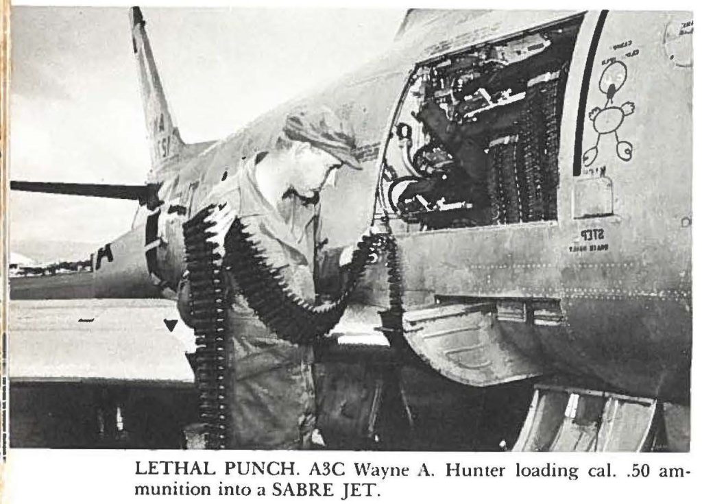 LETHAL PUNCH. A3C Wayne A. Hunter loading cal. .50 ammunition into a SABRE JET.