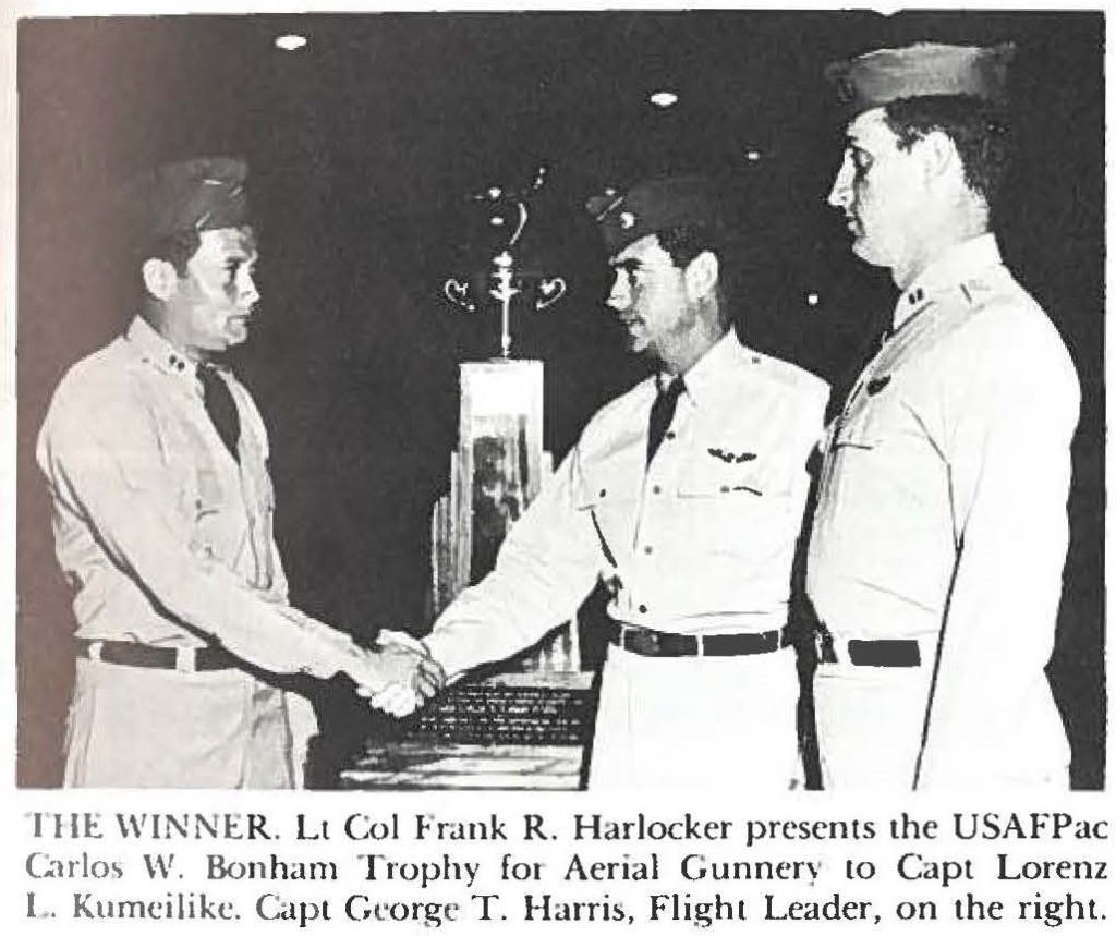 THE WINNER. Lt Col Frank R. Harlocker presents the USAFPac Carlos W. Bonham Trophy for Aerial Gunnery to Capt Lorenz L. Kumeilike. Capt George T. Harris, Flight Leader, on the right.