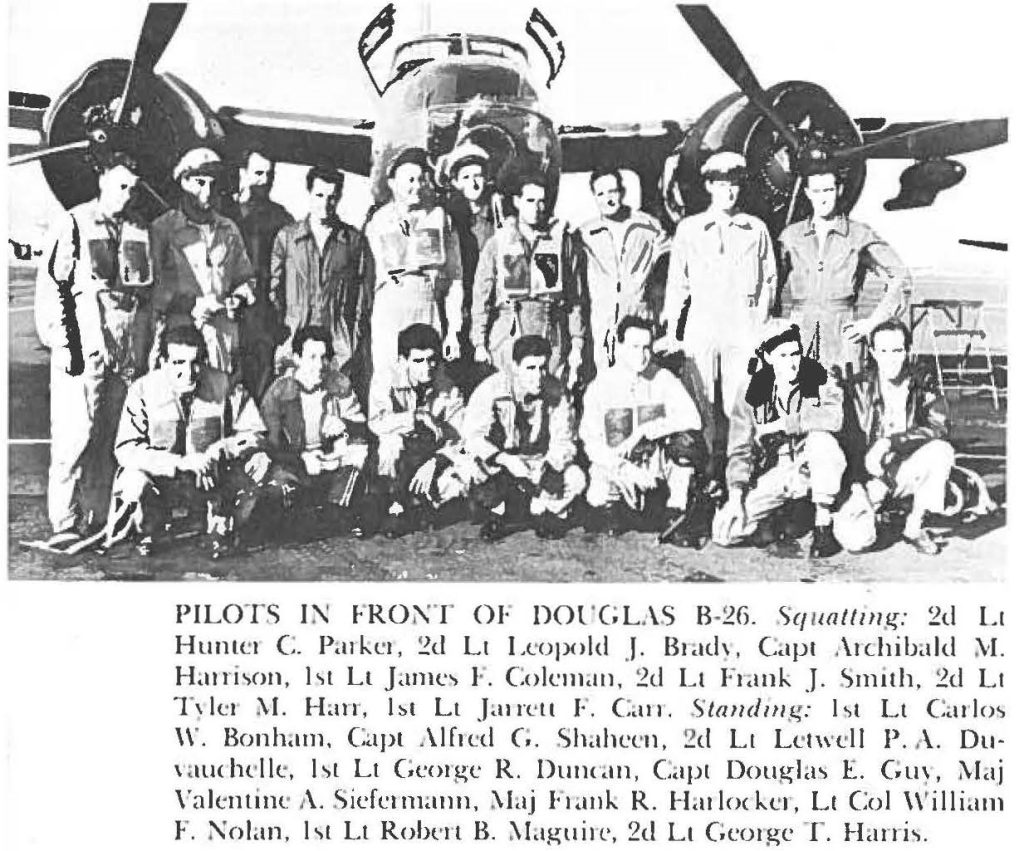 PILOTS IN FRONT OF DOUGLAS B-26. Squatting: 2d Lt Hunter C. Parker, 2d Lt Leopold J. Brady, Capt Archibald M. Harrison, 1st Lt James F. Coleman, 2nd Lt Frank J. Smith, 2d Lt Tyler M. Harr, 1st Lt Jarrett F. Carr, Standing: 1st Lt Carlos W. Bonham, Capt Alfred G. Sheen, 2nd Lt Letwell P. A. Duvauchelle, 1st Lt George R. Duncan, Capt Douglas E. Guy, May Valetine A. Siefermann, Maj Frank R. Harlocker, Lt Col William F. Nolan, 1st Lt Robert B. Maguire, 2nd Lt George T. Harris.