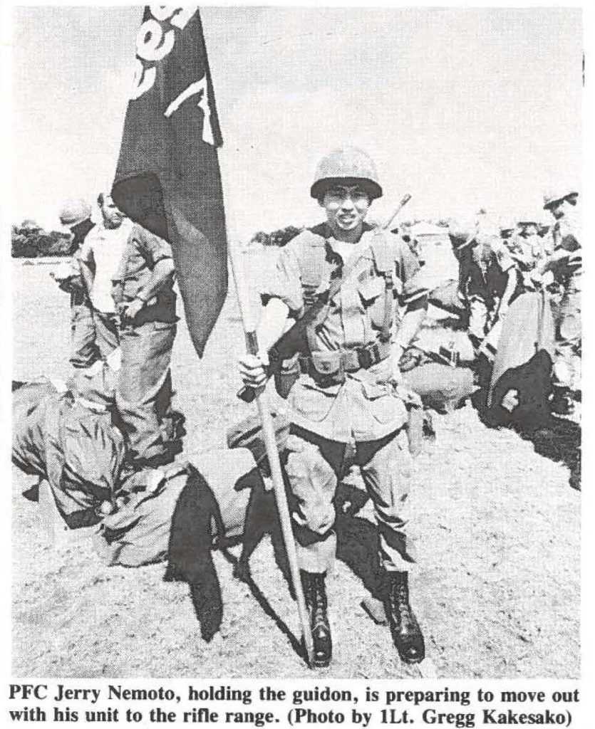 PFC Jerry Nemoto, holding the guidon, is preparing to move out with his unit to the rifle range. (Photo by 1Lt. Gregg Kakesako)