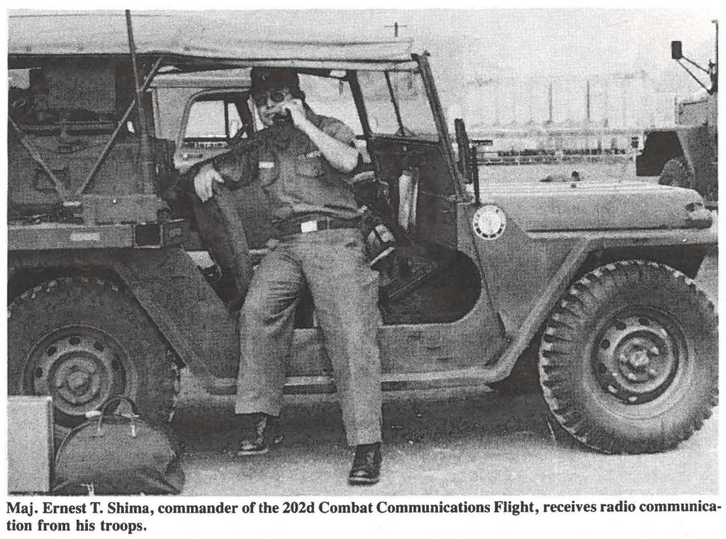 Maj. Ernest T. Shima, commander of the 202d Combat Communications Flight, receives radio communication from his troops.