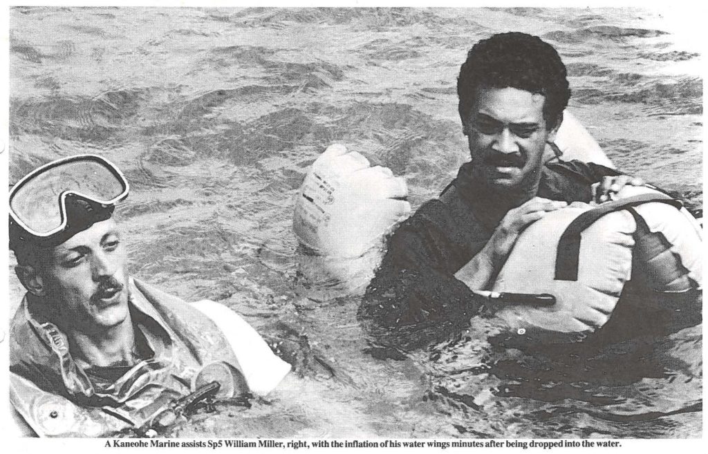 A Kaneohe Marine assists Sp5 William Miller, right, with the inflation of his water wings minutes after being dropped into the water.