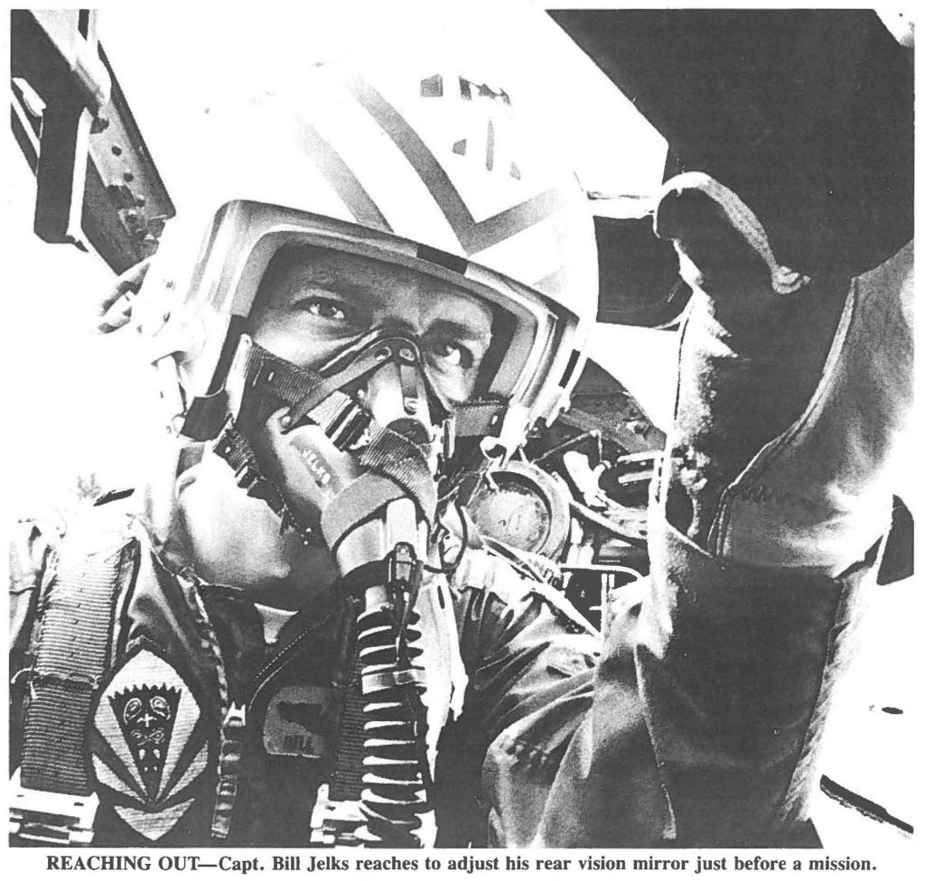 REACHING OUT-Capt. Bill Jelks reaches to adjust his rear vision mirror just before a mission.