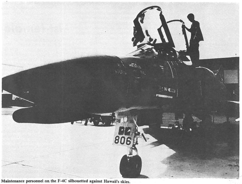 Maintenance personnel on the F-4C silhouetted against Hawaii's skies.