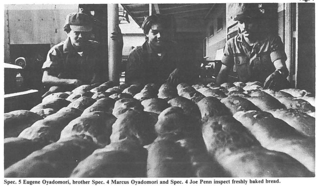 Spec. S Eugene Oyadomori, brother Spec. 4 Marcus Oyadomori and Spec. 4 Joe Penn inspect freshly baked bread.