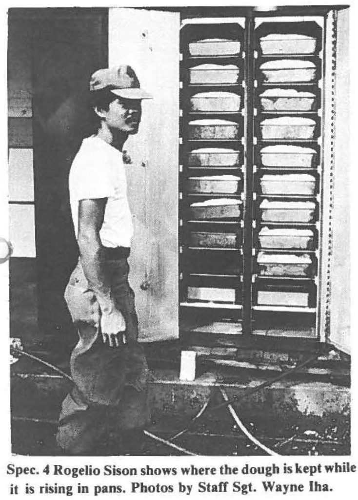 Spec. 4 Rogelio Sison shows where the dough is kept while it is rising in pans. Photos by Staff Sgt. Wayne Iha.