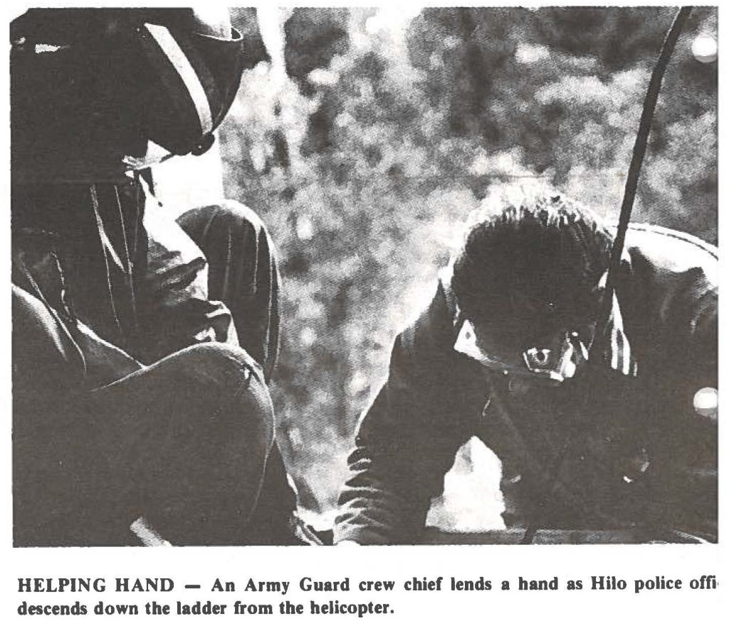 HELPING HAND - An Army Guard crew chief lends a hand as Hilo police officer descends down the ladder from the helicopter.