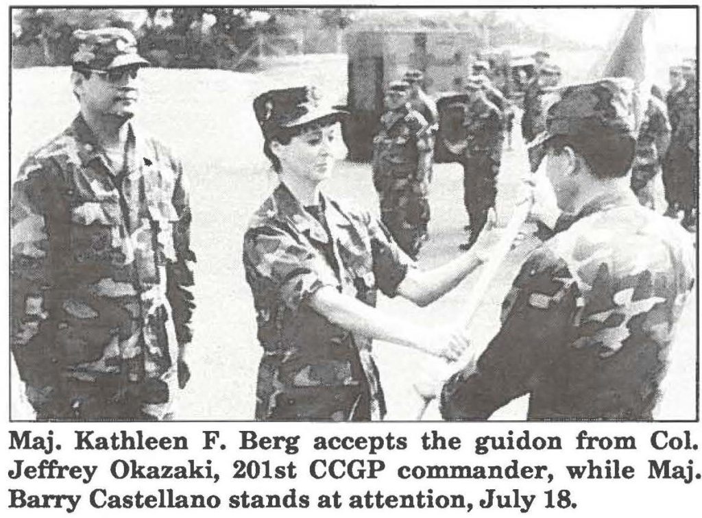 Maj. Kathleen F. Berg accepts the guidon from Col. Jeffrey Okazaki, 201st CCGP commander, while Maj. Barry Castellano stands at attention, July 18.
