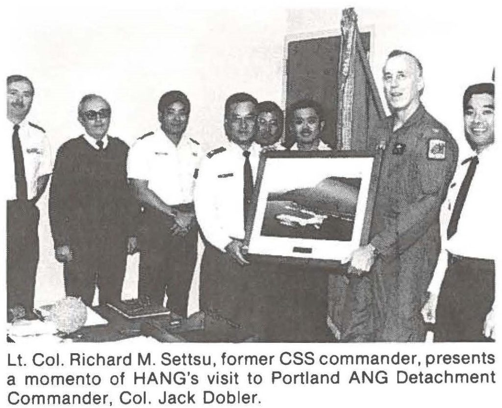 Lt. Col. Richard M. Settsu, former CSS commander, presents a momento of HANG's visit to Portland ANG Detachment Commander, Col. Jack Dobler.