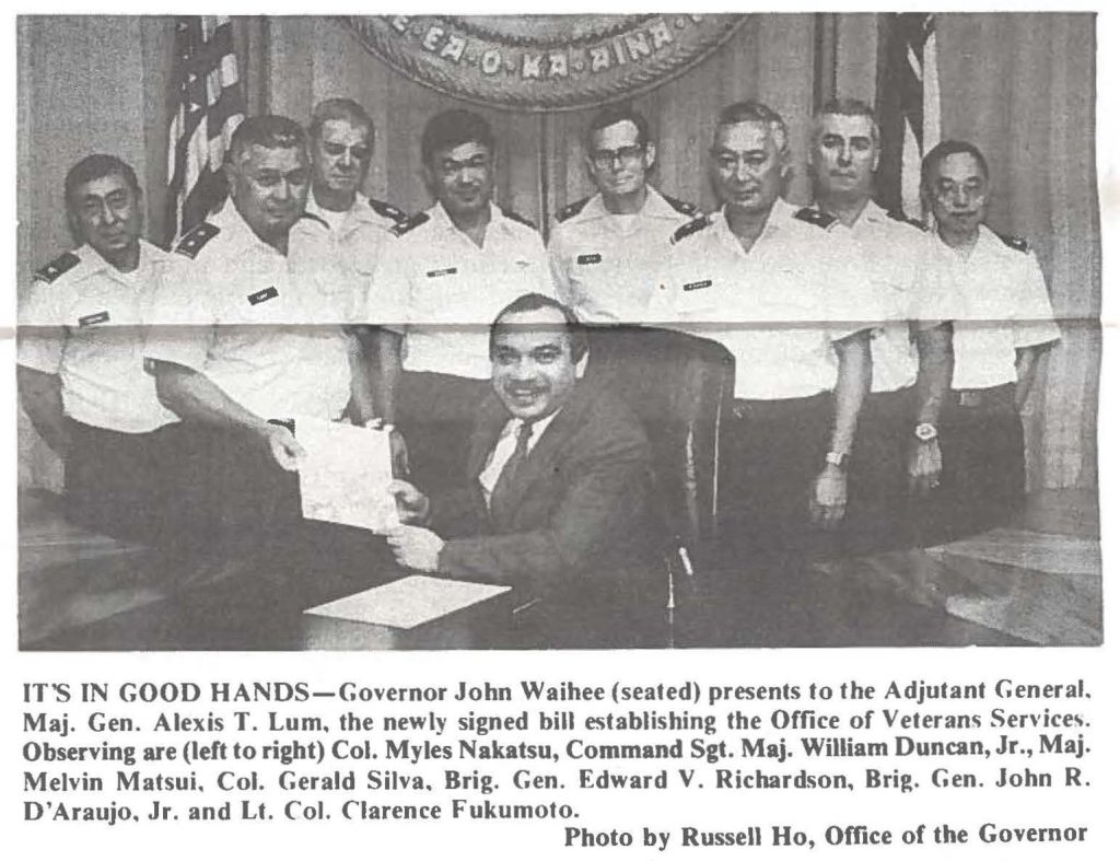 IT'S IN GOOD HANDS-Governor John Waihee (seated) presents to the Adjutant General. Maj. Gen. Alexis T. Lum, the newly signed bill establishing the Office of Veterans Service,. Observing are (left to right) Col. Myles Nakatsu, Command Sgt. Maj. William Duncan, Jr., Maj. Melvin Matsui. Col. Gerald Silva. Brig. Gen. Edward V. Richardson, Brig. Gen. John R. D'Araujo, Jr. and Lt. Col. Clarence Fukumoto. Photo by Russell Ho, Office of the Governor