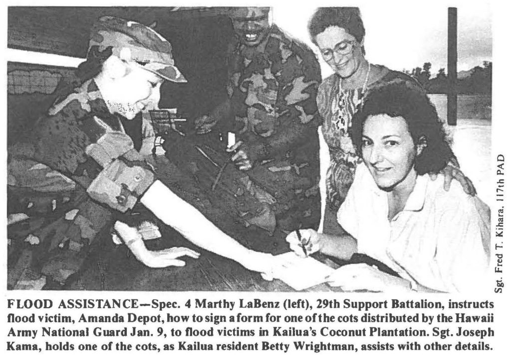 FLOOD ASSISTANCE-Spec. 4 Marthy LaBenz (left), 29th Support Battalion, instructs flood victim, Amanda Depot, how to sign a form for one of the cots distributed by the Hawaii Army National Guard Jan. 9, to flood victims in Kailua's Coconut Plantation. Sgt. Joseph Kama, holds one of the cots, as Kailua resident Betty Wrightman, assists with other details.