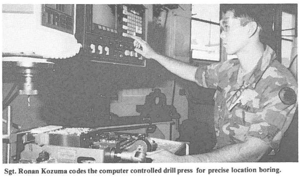 Sgt. Ronan Kozuma codes the computer controlled drill press for precise location boring.