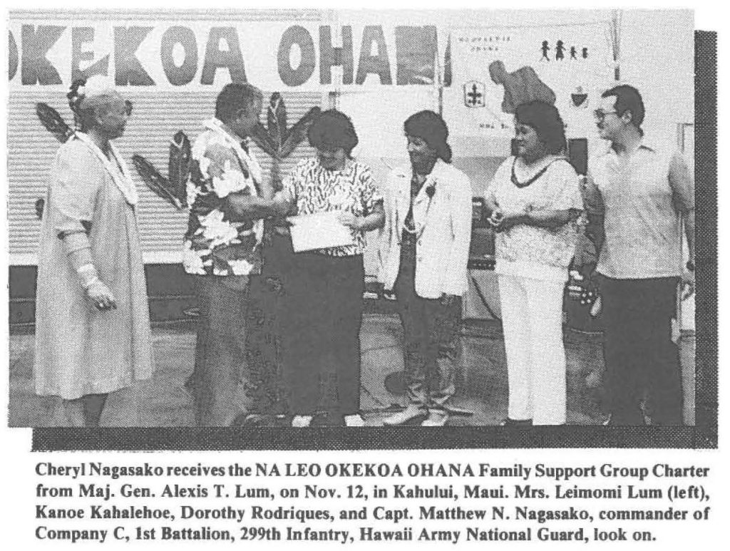 Cheryl Nagasako receives the NA LEO OKEKOA OHANA Family Support Group Charter from Maj. Gen. Alexis T. Lum, on Nov. 12, in Kahulul, Maui. Mrs. Leimomi Lum (left), Kanoe Kahalehoe, Dorothy Rodriques, and Capt. Matthew N. Nagasako, commander of Company C, 1st Battalion, 299th Infantry, Hawaii Army National Guard, look on.