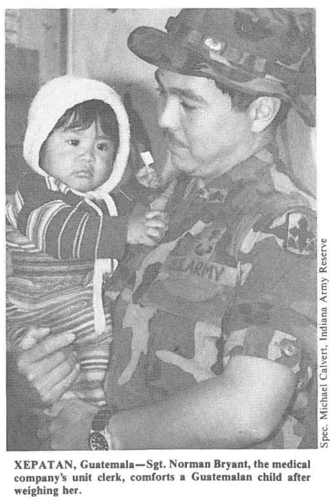 XEPATAN, Guatemala-Sgt. Norman Bryant, the medical company's unit clerk, comforts a Guatemalan child after weighing her.