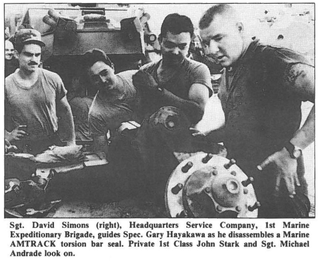 Sgt. DHid Simons (right), Headquarters Service Company, 1st Marine Expeditionary Brigade, guides Spec. Gary Hayakawa as he disassembles a Marine AMTRACK torsion bar seal. Private 1st Class John Stark and Sgt. Michael Andrade look on.