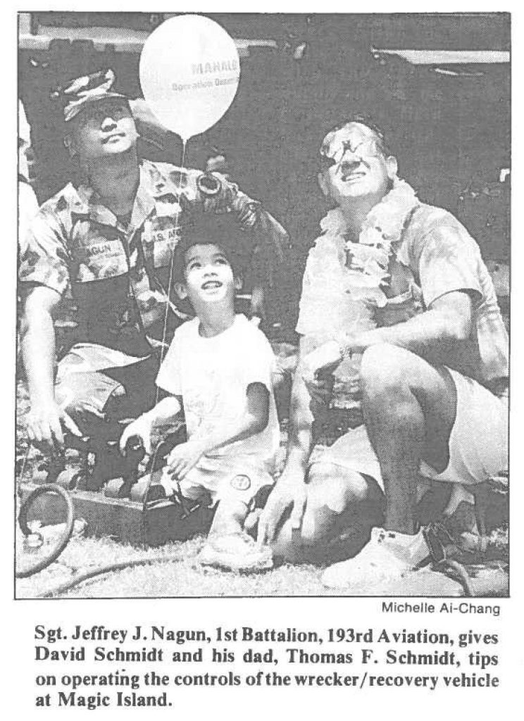 Sgt. Jeffrey J. Nagun, 1st Battalion, 193rd Aviation, gives David Schmidt and his dad, Thomas F. Schmidt, tips on operating the controls of the wrecker /recovery vehicle at Magic Island.