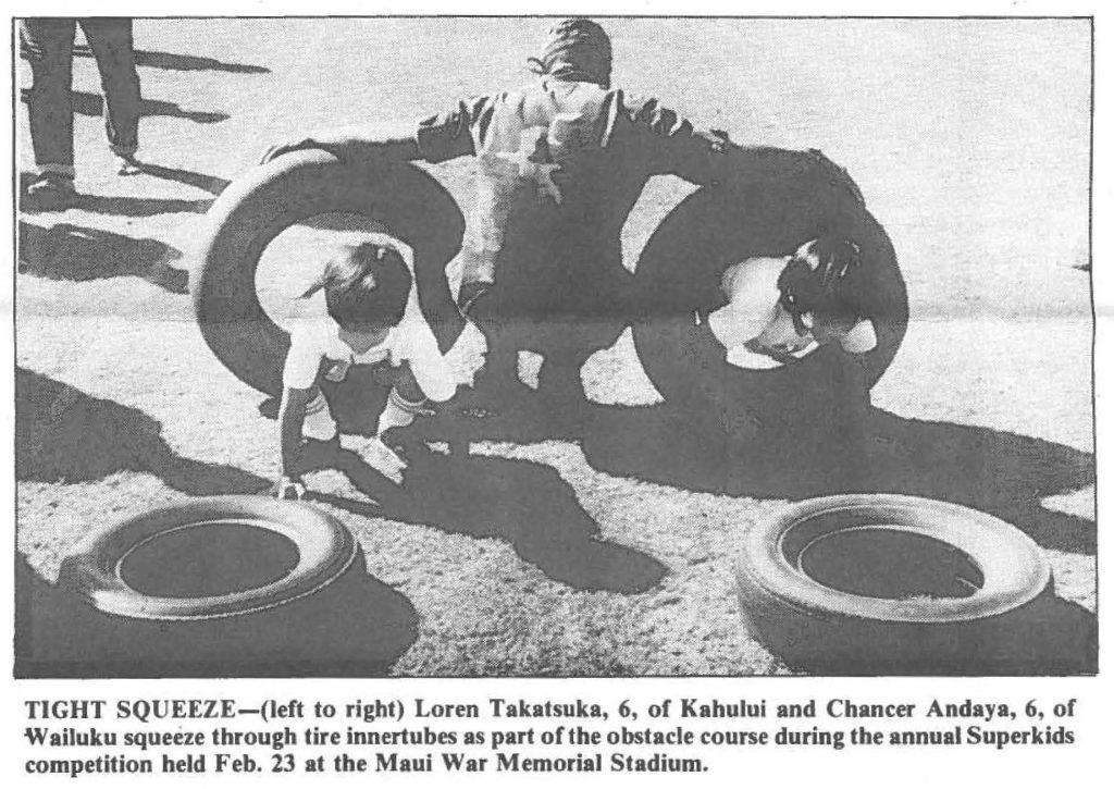 TIGHT SQUEEZE-(left to right) Loren Takatsuka, 6, of Kahului and Chancer Andaya, 6, of Wailuku squeeze through tire innertubes as part of the obstacle course during the annual Superkids competition held Feb. 23 at the Maui War Memorial Stadium.