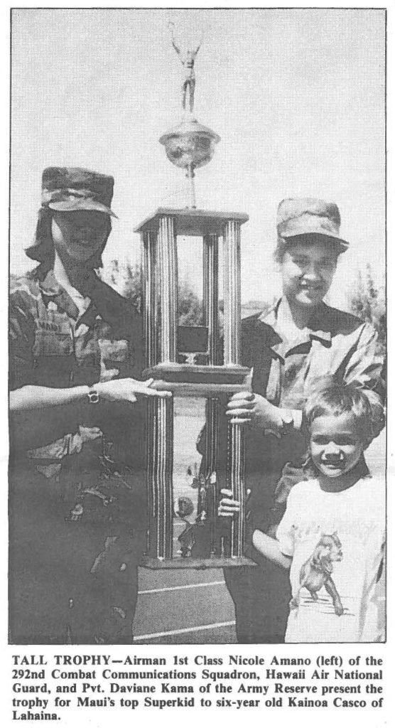 TALL TROPHY-Airman 1st Class Nicole Amano (left) of the 292nd Combat Communications Squadron, Hawaii Air National Guard, and Pvt. Daviane Kama of the Army Reserve present the trophy for Maui's top Superkid to six-year old Kainoa Casco of Lahaina.