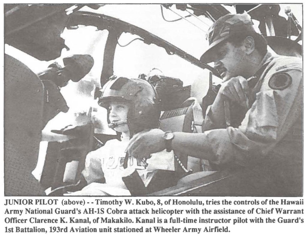 JUNIOR PILOT - - Timothy W. Kubo, 8, of Honolulu, tries the controls of the Hawaii Army National Guard's AH-lS Cobra attack helicopter with the assistance of Chief Warrant Officer Clarence K. Kanai, of Makakilo. Kanai is a full-time instructor pilot with the Guard's 1st Battalion, 193rd Aviation unit stationed at Wheeler Army Airfield.