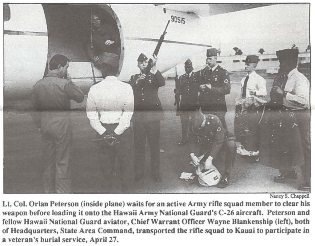 Lt. Col. Orlan Peterson (inside plane) waits for an active Army rifle squad member to clear his weapon before loading it onto the Hawaii Army National Guard's C-26 aircraft. Peterson and fellow Hawaii National Guard aviator, Chief Warrant Officer Wayne Blankenship (left), both or Headquarters, State Area Command, transported the rifle squad to Kauai to participate in a veteran's burial service, April 27.