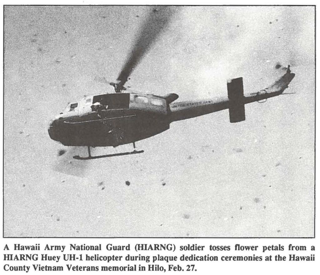 A Hawaii Army National Guard (HIARNG) soldier tosses flower petals from a HARNG Huey UH-1 helicopter during plaque dedication ceremonies at the Hawaii County Vietnam Veterans memorial in Hilo, Feb. 27.