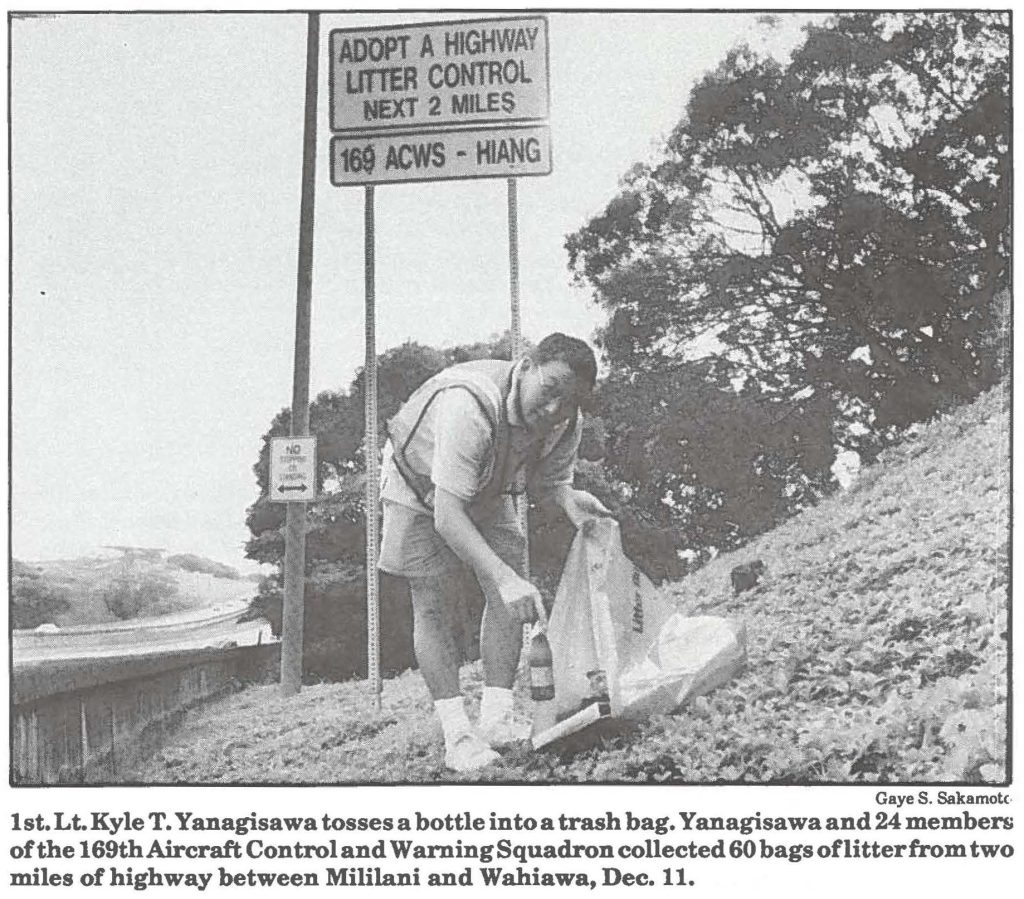1st. Lt.Kyle T. Yanagisawa tosses a bottle into a trash bag. Yanagisawa and 24 members of the 169th Aircraft Control and Warning Squadron collected 60 bags of litter from two miles of highway between Mililani and Wahiawa, Dec. 11.
