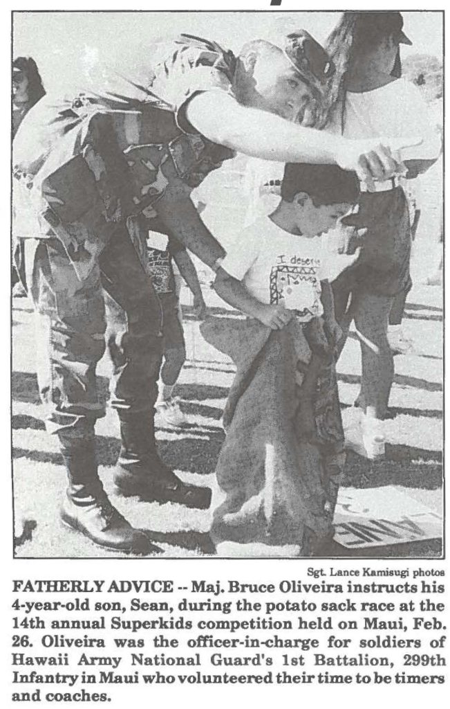 FATHERLY ADVICE --Maj. Bruce Oliveira instructs his 4-year-old son, Sean, during the potato sack race at the 14th annual Superkids competition held on Maui, Feb. 26. Oliveira was the officer-in-charge for soldiers of Hawaii Army National Guard's 1st Battalion, 299th Infantry in Maui. who volunteered their time to be timers and coaches.