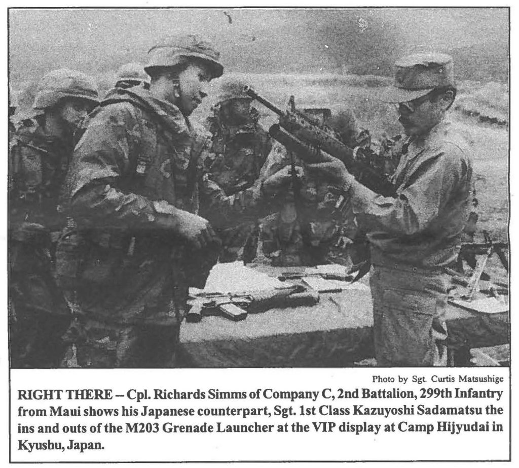 RIGHT THERE - Cpl. Richards Simms of Company C, 2nd Battalion, 299th Infantry from Maui shows his Japanese counterpart, Sgt. 1st Class Kazuyoshi Sadamatsu the ins and outs of the M203 Grenade Launcher at the VIP display at Camp Hijyudai in Kyushu, Japan.