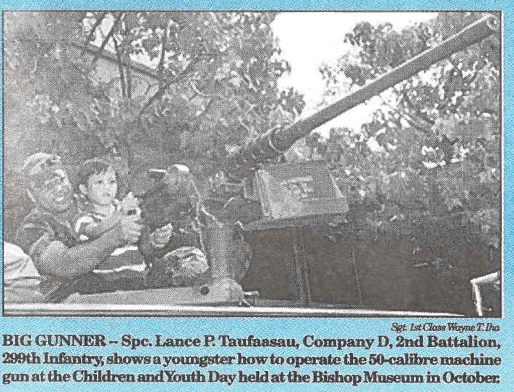 BIG GUNNER -- Spc. Lance P. Taufaasau, Company D, 2nd Battalion, 299th Infantry, shows a youngster how to operate the 50-calibre machine gun at the Children and Youth Day held at the Bishop Museum in October.