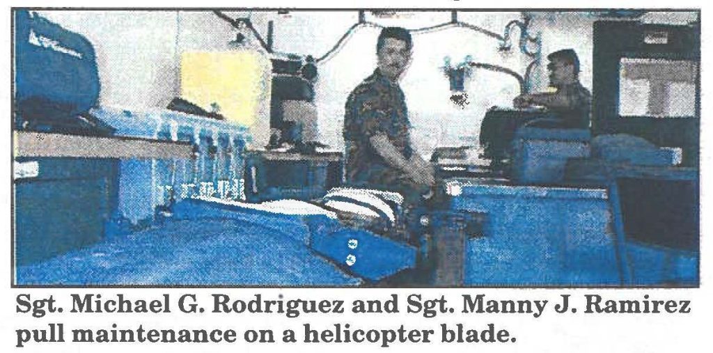 Sgt. Michael G. Rodriguez and Sgt. Manny J. Ramirez pull maintenance on a helicopter blade.