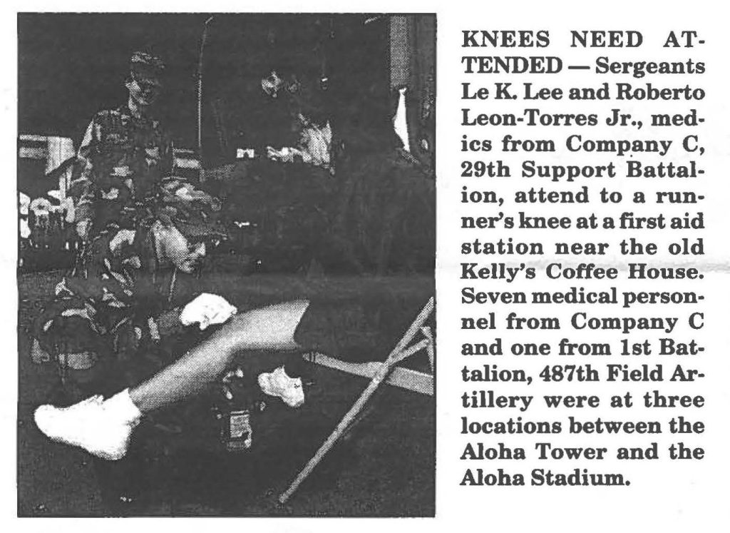 KNEES NEED ATTENDED - Sergeants Le K. Lee and Roberto Leon-Torres Jr., medics from Company C, 29th Support Battalion, attend to a runner's knee at a first aid station near the old Kelly's Coffee House. Seven medical personnel from Company C and one from 1st Battalion, 487th Field Artillery were at three locations between the Aloha Tower and the Aloha Stadium.
