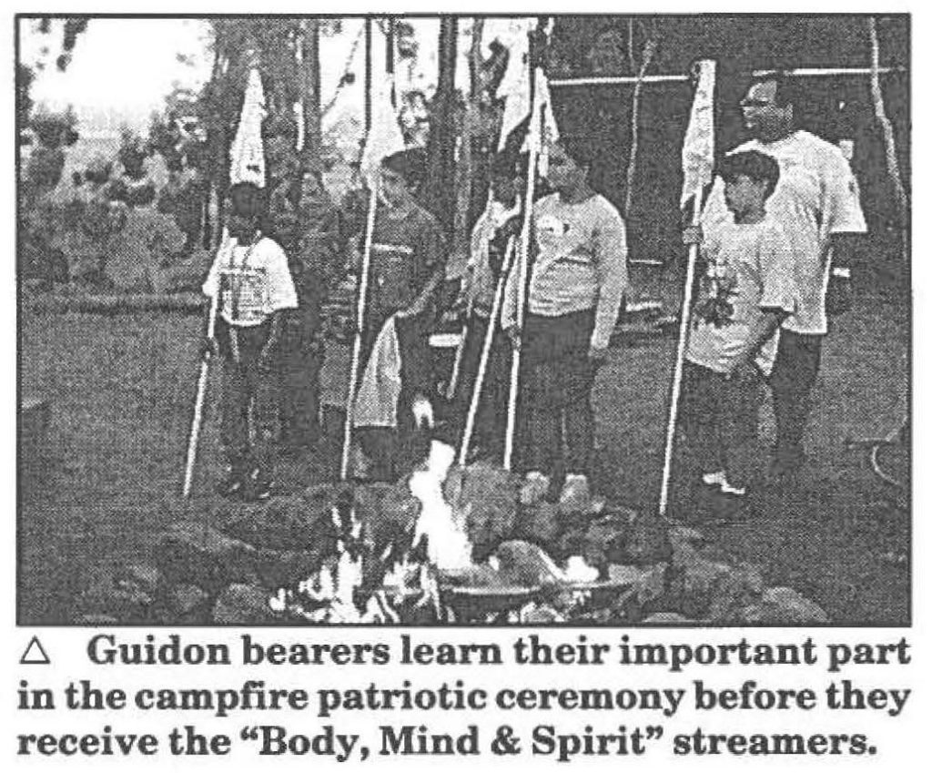 Guidon bearers learn their important part in the campfire patriotic ceremony before they receive the "Body, Mind & Spirit" streamers.