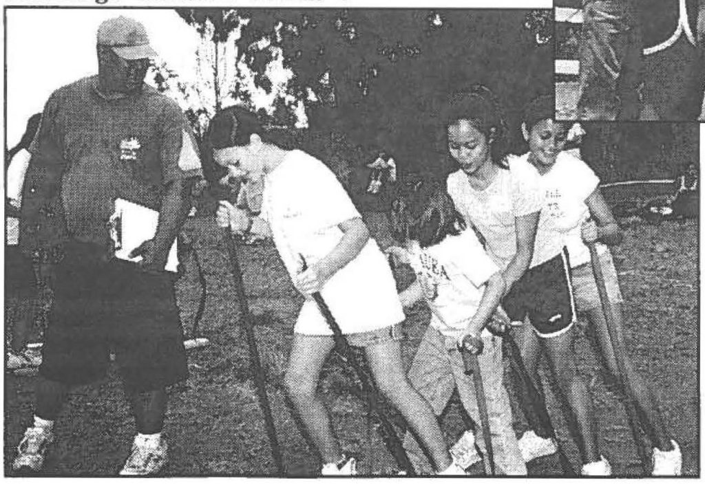 Adult leader, Henry Waiau (DDR) watches as Aja Comella (291CBCS), Breanna Doria (B/2-299IN), Shastiana Madamba (C/2-299IN) and Zena Tapuro (Det 55, STARC) master the Team Challenge "ski walk" event.