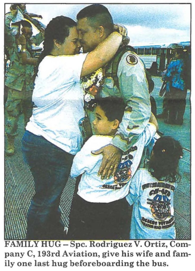 FAMILY HUG - Spc. Rodriguez V. Ortiz, Company C, 193rd Aviation, give his wife and family one last hug before boarding the bus.