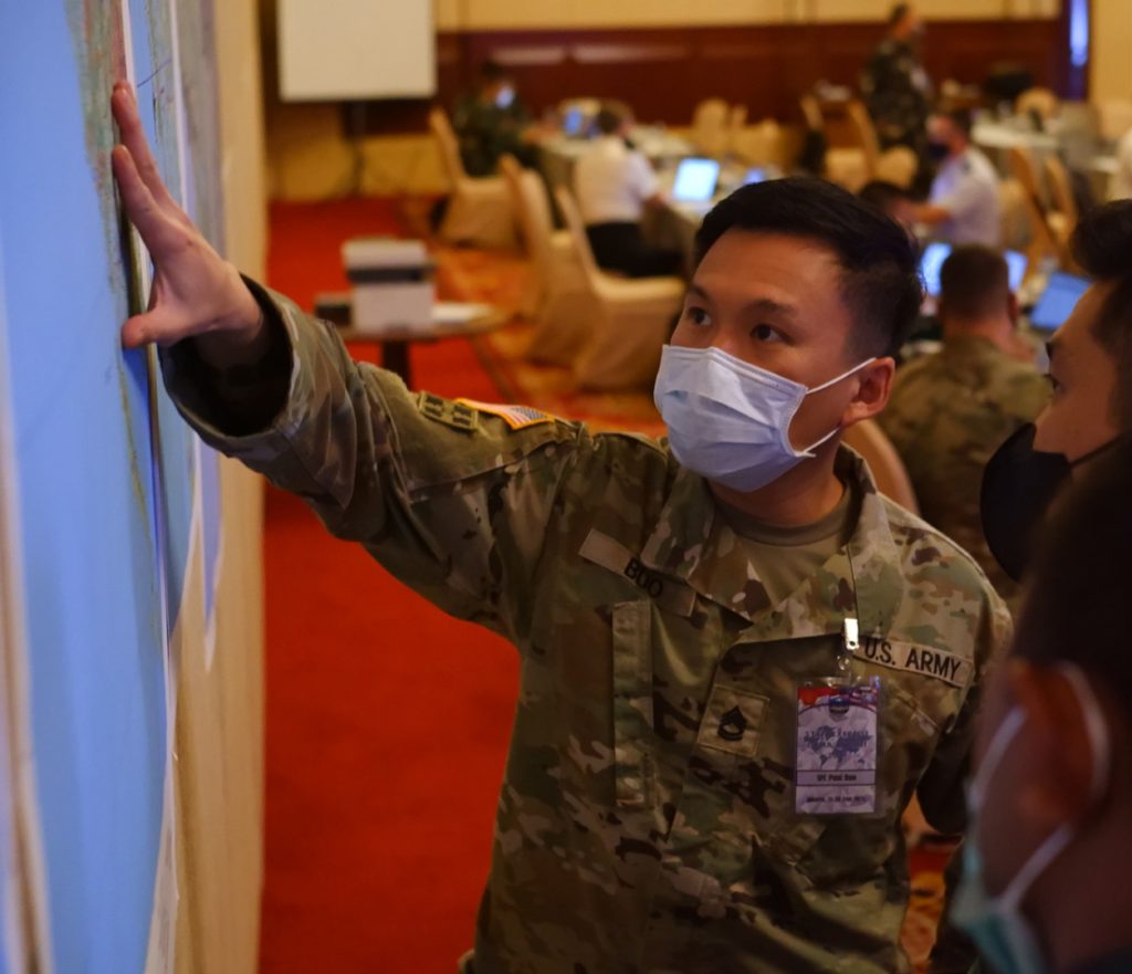 Sgt. First Class Paul Buo, US Army, 5th Security Force Assistance Brigade, reviews the exercise map with his Tentara Nasional Indonesia (TNI) counterparts during the mission analysis portion of Joint Exercise GEMA BHAKTI (GB21) September 21, 2021, Jakarta Indonesia. GB21 is a Chairman, Joint Chiefs of Staff (CJCS) staff exercise (STAFFEX) between USINDOPACOM (and components) and TNI (and components), and is designed to improve joint, operational-level staff planning and processes. It also promotes positive military relations, assuring security and stability in the region, increases cultural awareness, and enhances command and control proficiency. (U.S. Air National Guard photo by Master Sgt. Andrew Jackson)